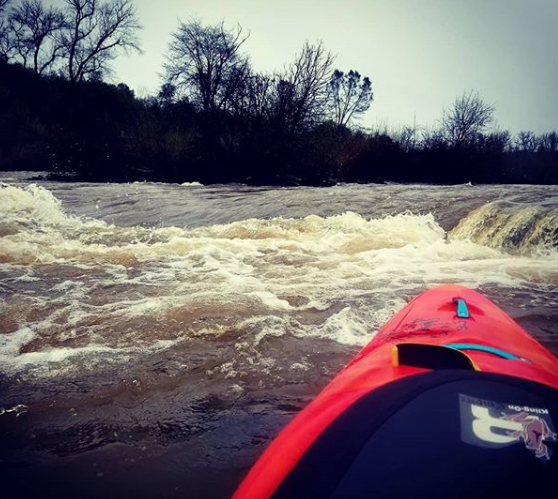 a man riding a motorcycle down a river