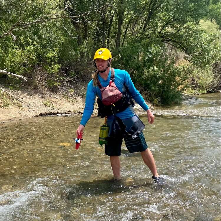 a man standing next to a body of water