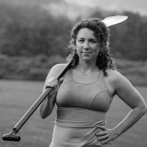 a woman holding a baseball bat on a field