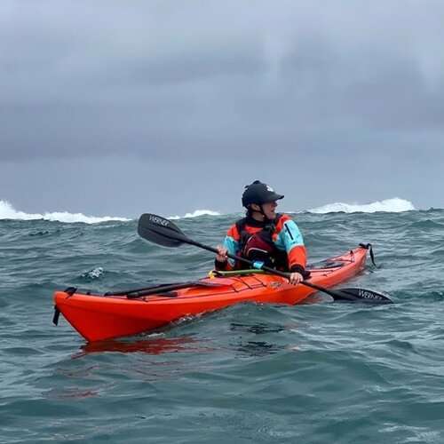 a man riding on the back of a boat in a body of water