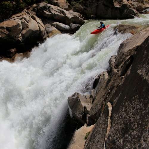 a man riding a wave on top of a rock