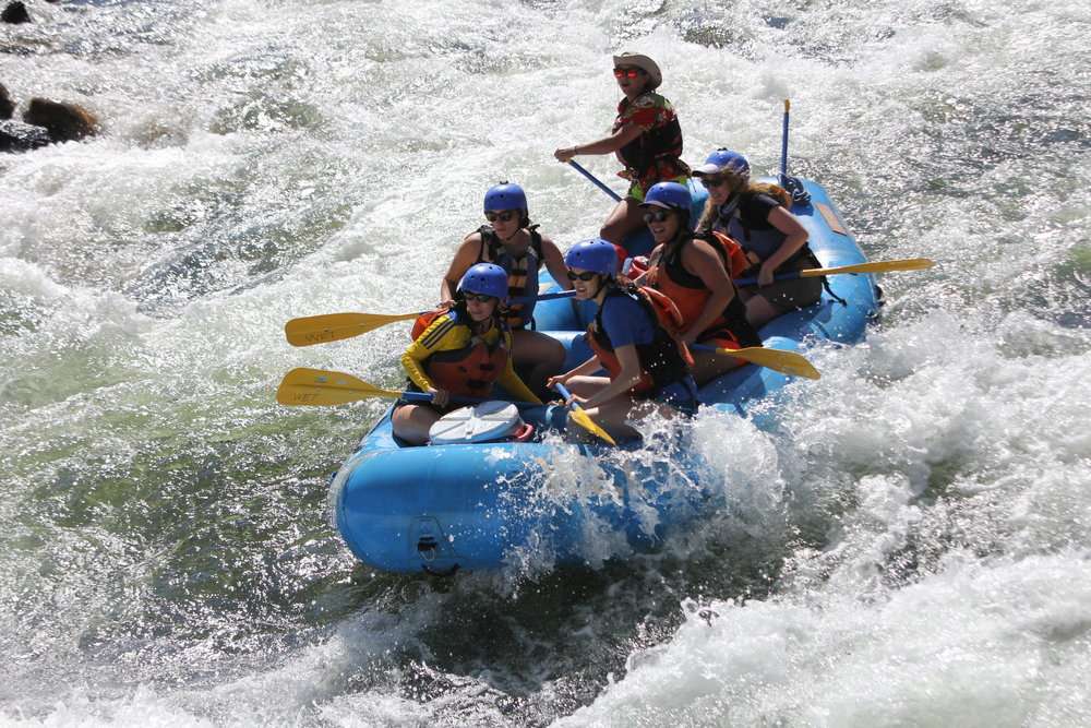 a man riding a wave on a raft in a body of water