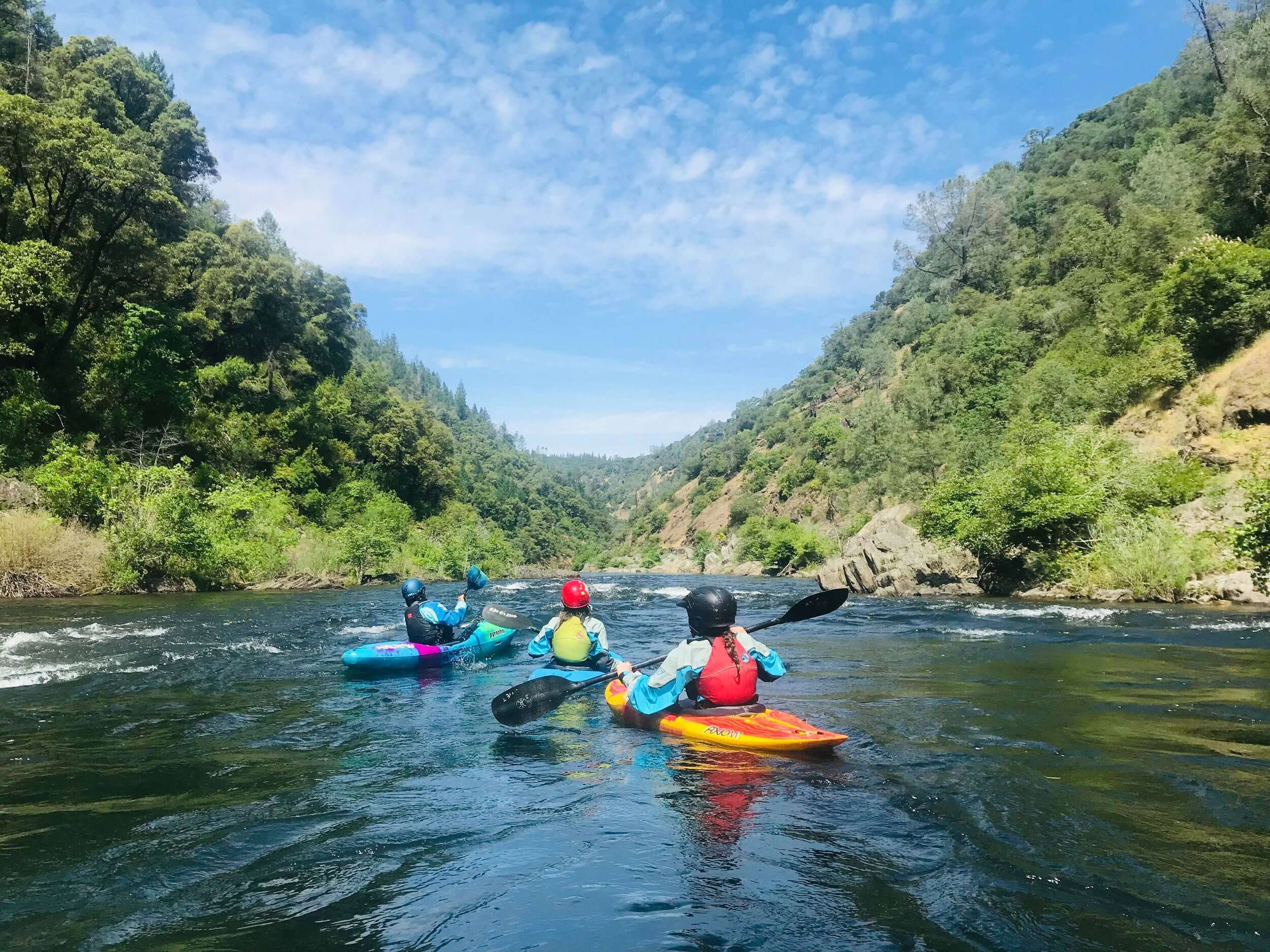 a group of people riding on the back of a boat in the water