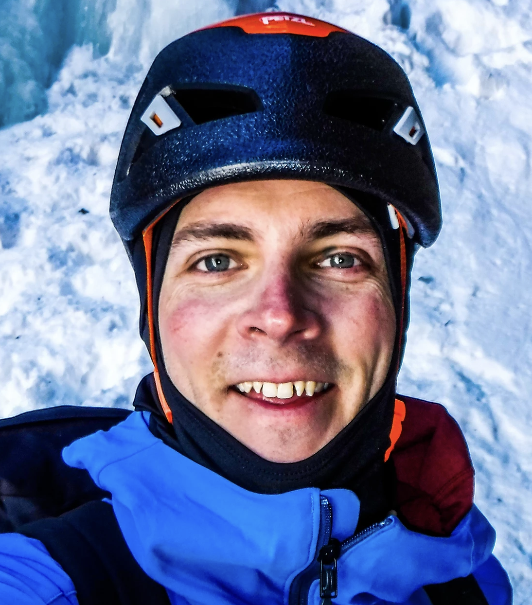 a man wearing a hat and smiling at the camera