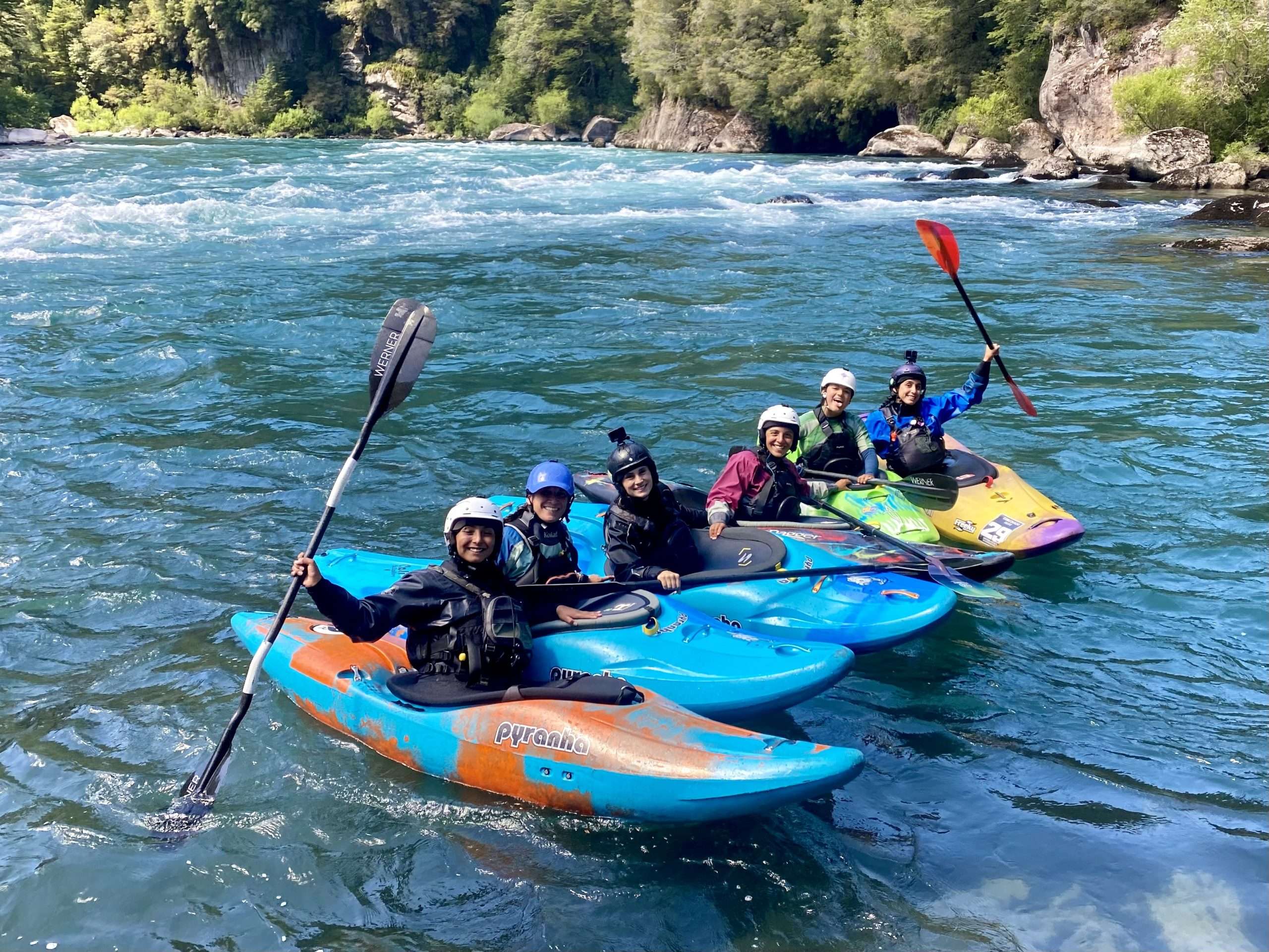 a group of people riding on the back of a boat in the water